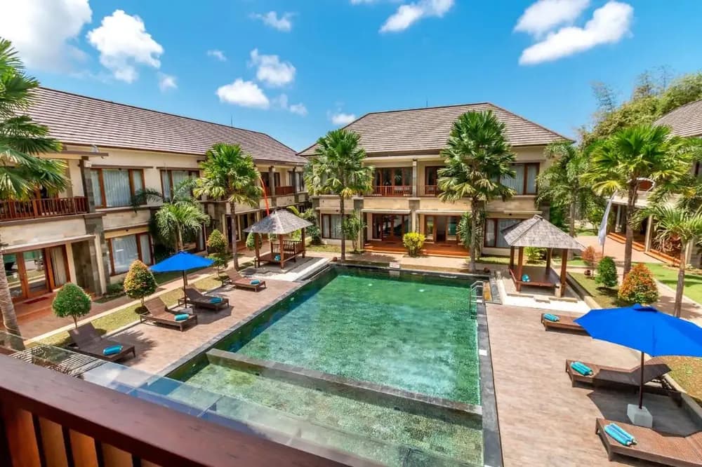 Resort pool deck framed by palms at Jimbaran, Bali