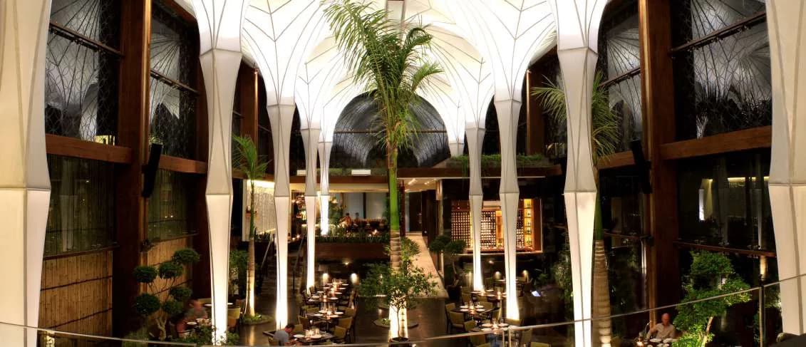 Merah Putih restaurant interior at night, tall fluted columns rising to a vaulted roof