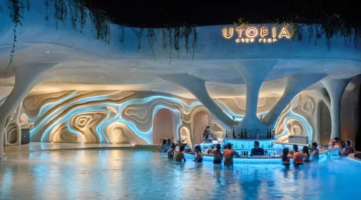 Luna Beach Club's sculpted pool lit at night, guests in the water
