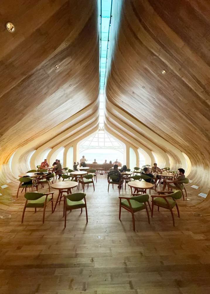 Interior of a bamboo structure, a woven vault rising above the dining floor