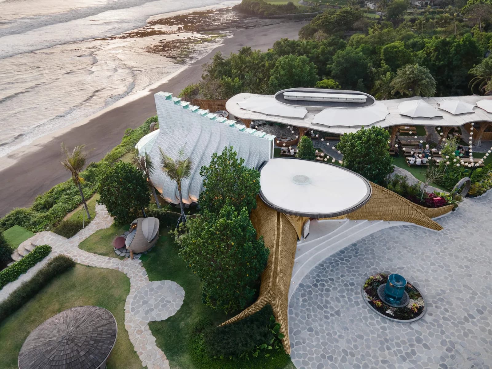 Luna Beach Club at Nuanu, Bali: the completed bamboo-arched beach club above the shoreline, seen from the air